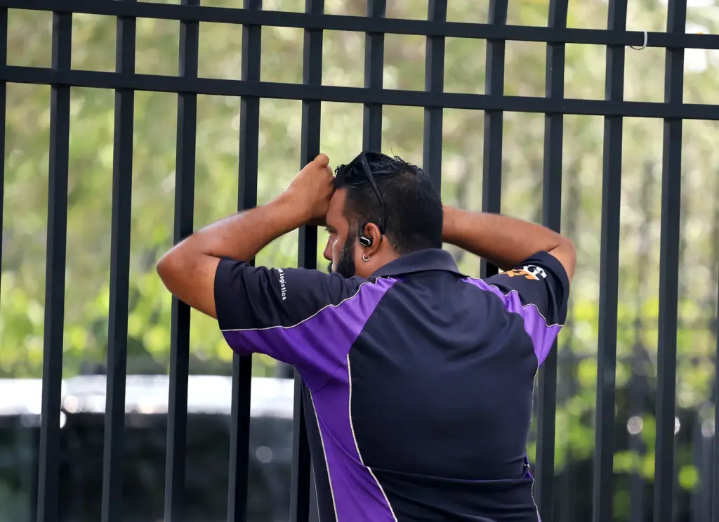 Guillermo Garcia waits outside the fence for word from a...