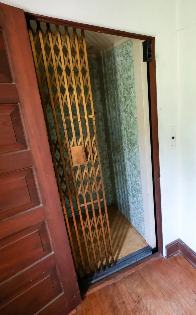 The elevator in Merrywood has a scissor gate and walls...