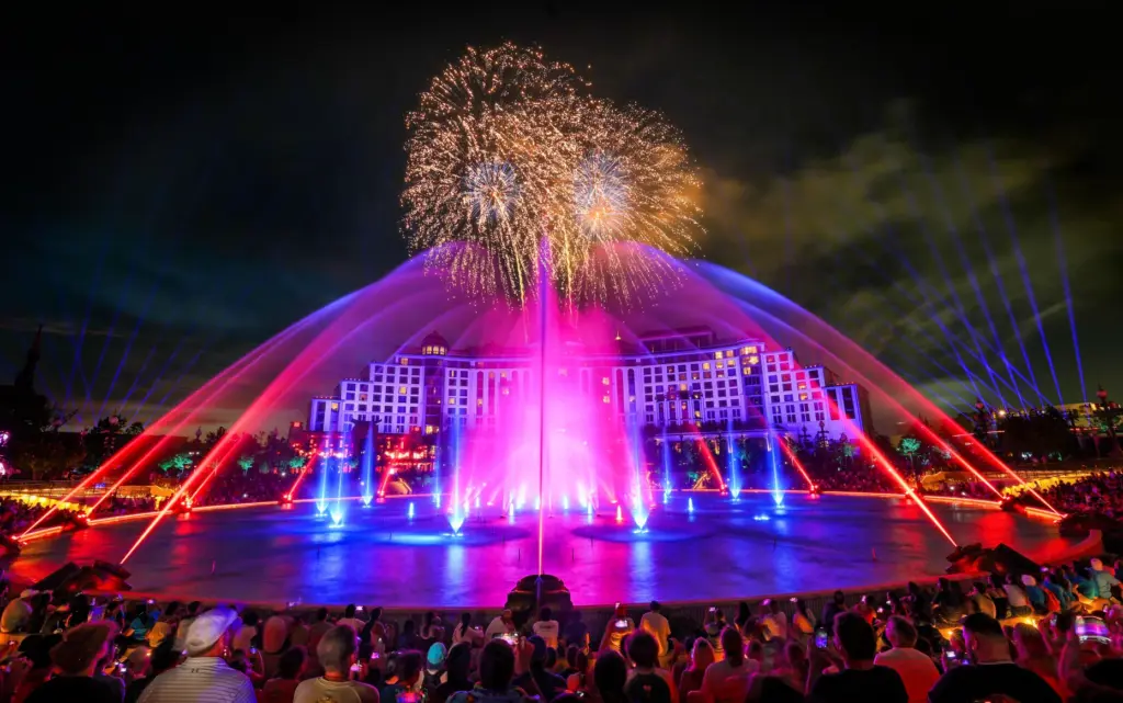 Guests watch the debut of the first nighttime finale fireworks...