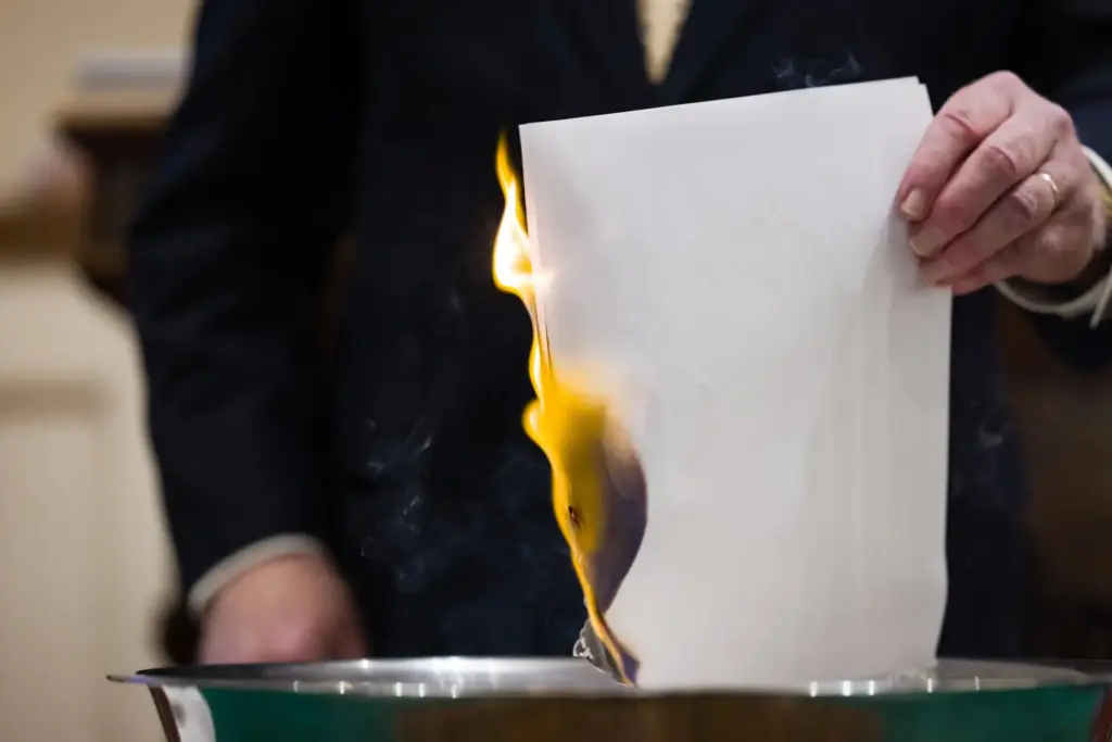 John Jackman, who leads Trinity Moravian Church, burns a list names of those with cleared debt.