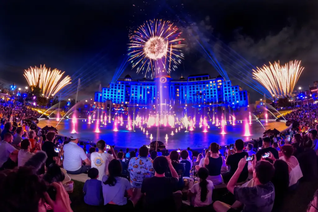 Guests watch the debut of the first nighttime finale fireworks...