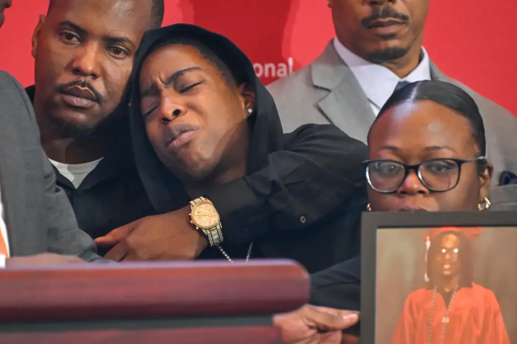 Azariah Mayhorn is comforted by uncle Trevon Petty, left, as...