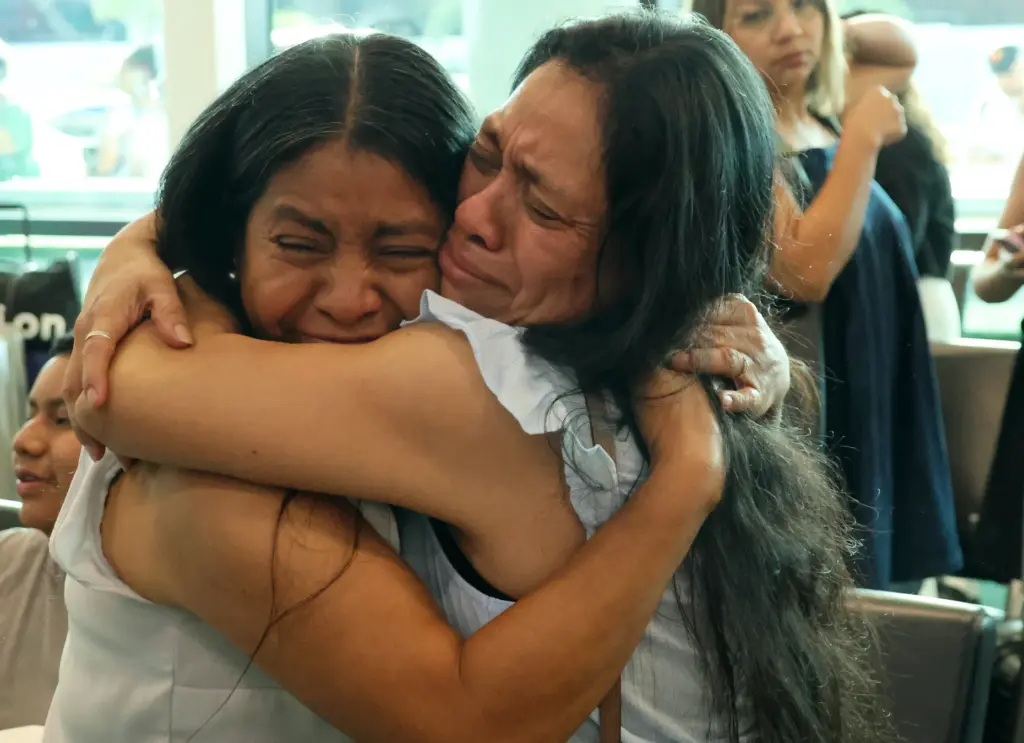 Olga Perez, right, longtime translator for the Guatemala Maya Center in Lake Worth Beach, hugs her sister, Mirna, as she prepares to board a flight to Guatemala City on Monday at Fort Lauderdale-Hollywood International Airport. A refugee from violence in her country decades ago, she self-deported after being detained by ICE. (Joe Cavaretta/South Florida Sun Sentinel)
