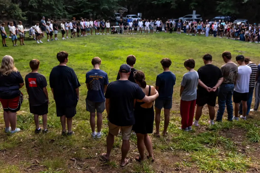 Community members gather during a student-organized vigil at Duncan Woods...