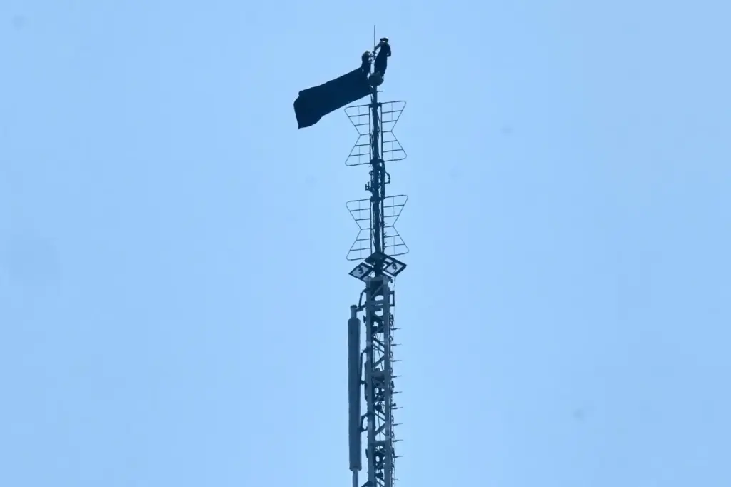 A person is shown atop the spire of the Empire...