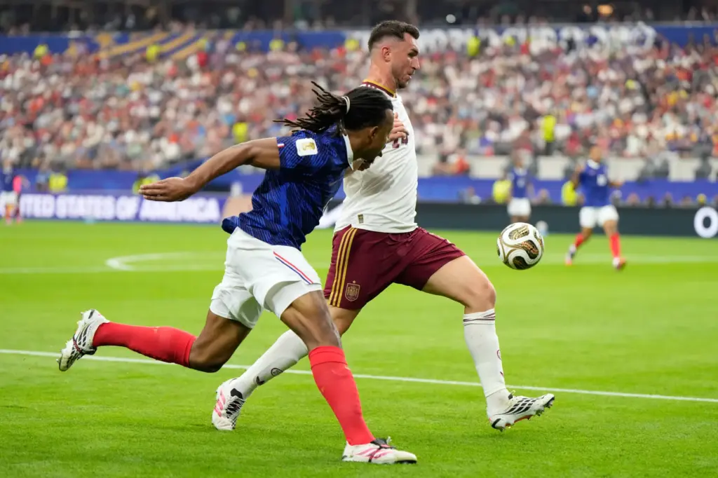 France’s Jules Kounde, left, vies for the ball with Spain’s...