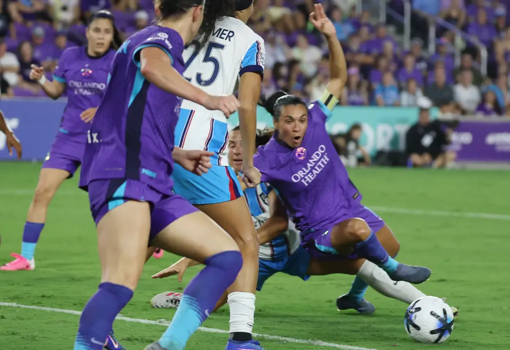 Orlando player Marta (bottom) falls attempting to kick a goal...