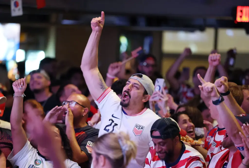 USA soccer fans cheer after a USA goal during a...