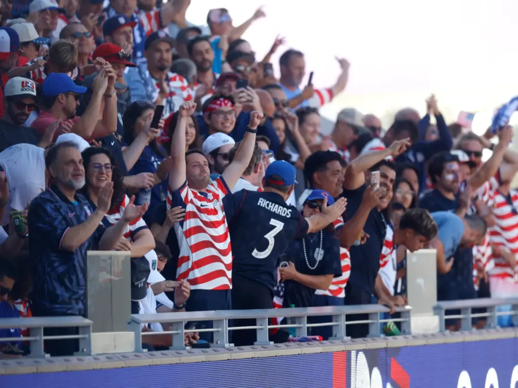 Fans celebrate a goal by United States’ Folarin Balogun (20)...