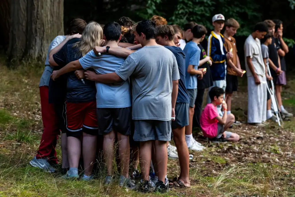 Community members gather during a student-organized vigil at Duncan Woods...