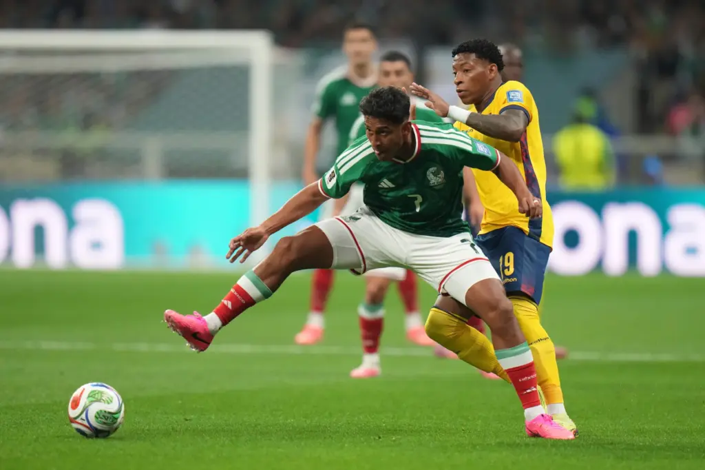 Mexico’s Luis Romo (7), left, fights for the ball with...