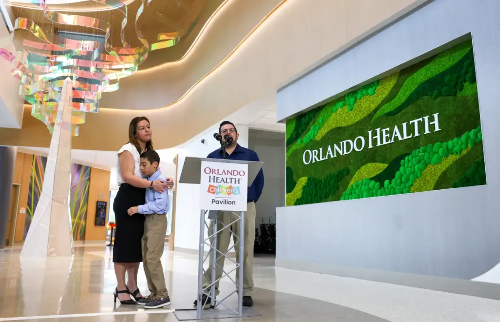 12-year-old Myles Murillo hugs mom Katie as dad Alan speaks...
