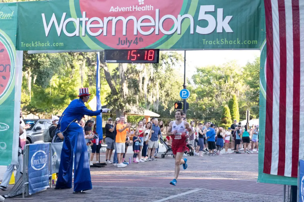 First place runner Garrett Drogosch crosses the finish line during...