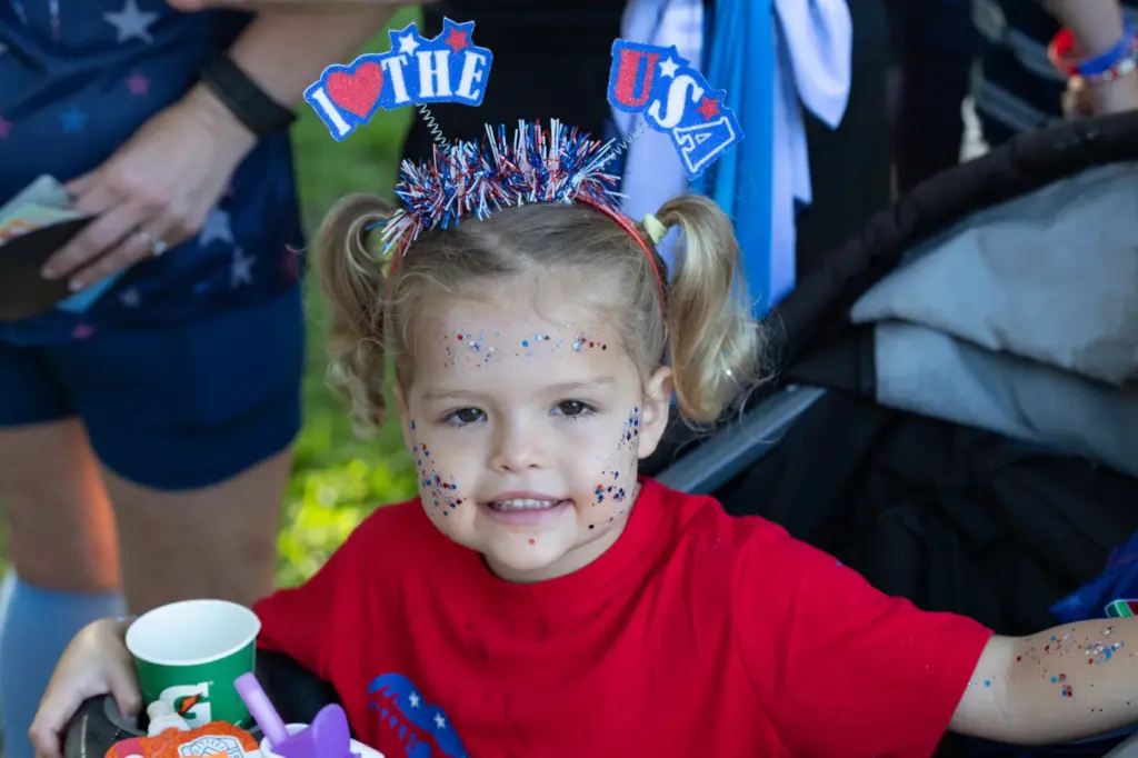 Girl smiles for a photo in her red, white and...