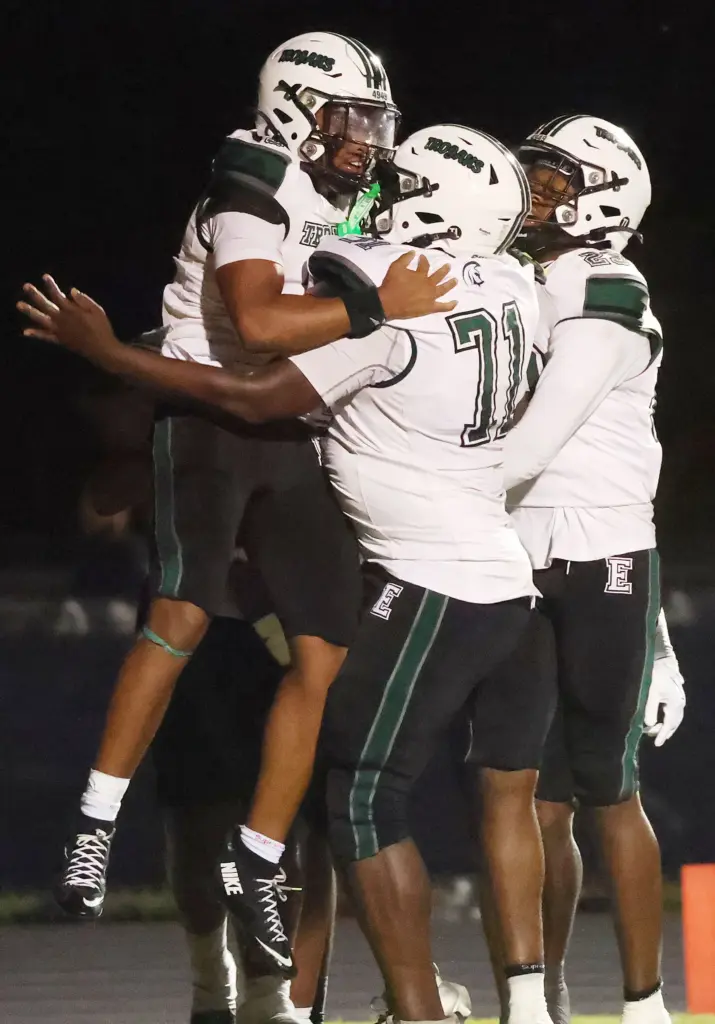 Evans player Daveon Williams (left) celebrates after scoring a touchdown...