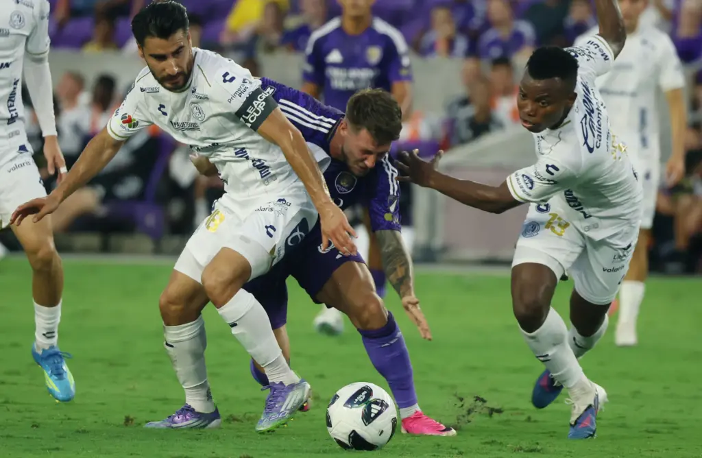 Orlando player Marco Pasalic (middle) fights for control with Atletico...