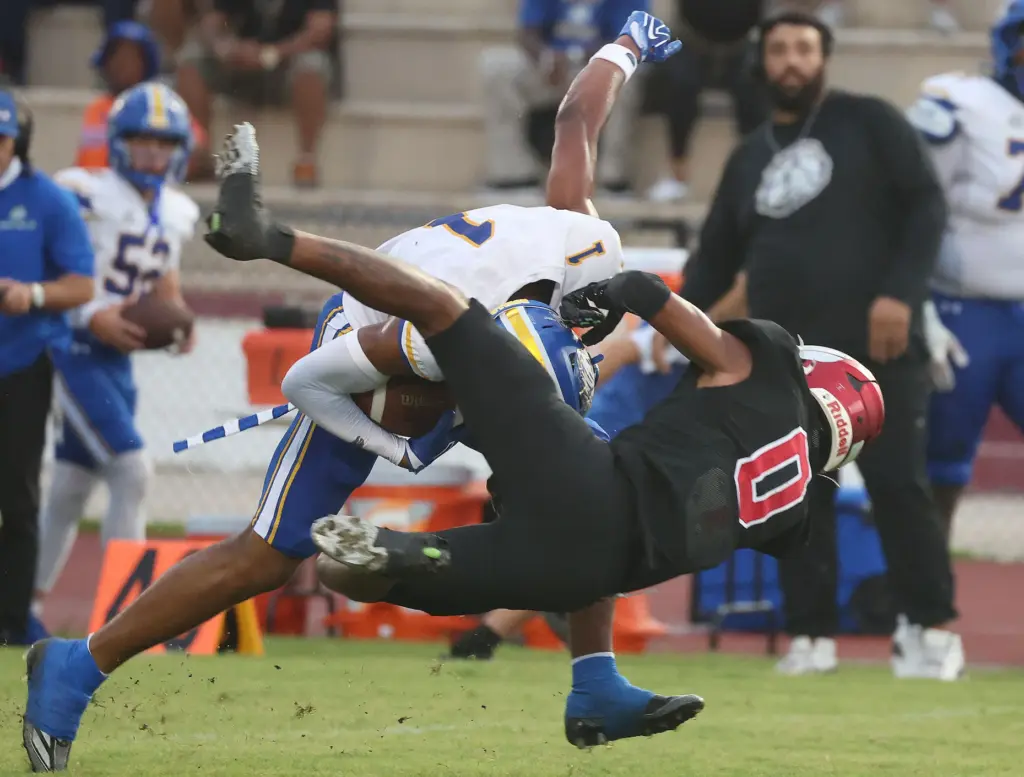TFA receiver Jaiziah Battle (1) runs over Edgewater defender Torrey...