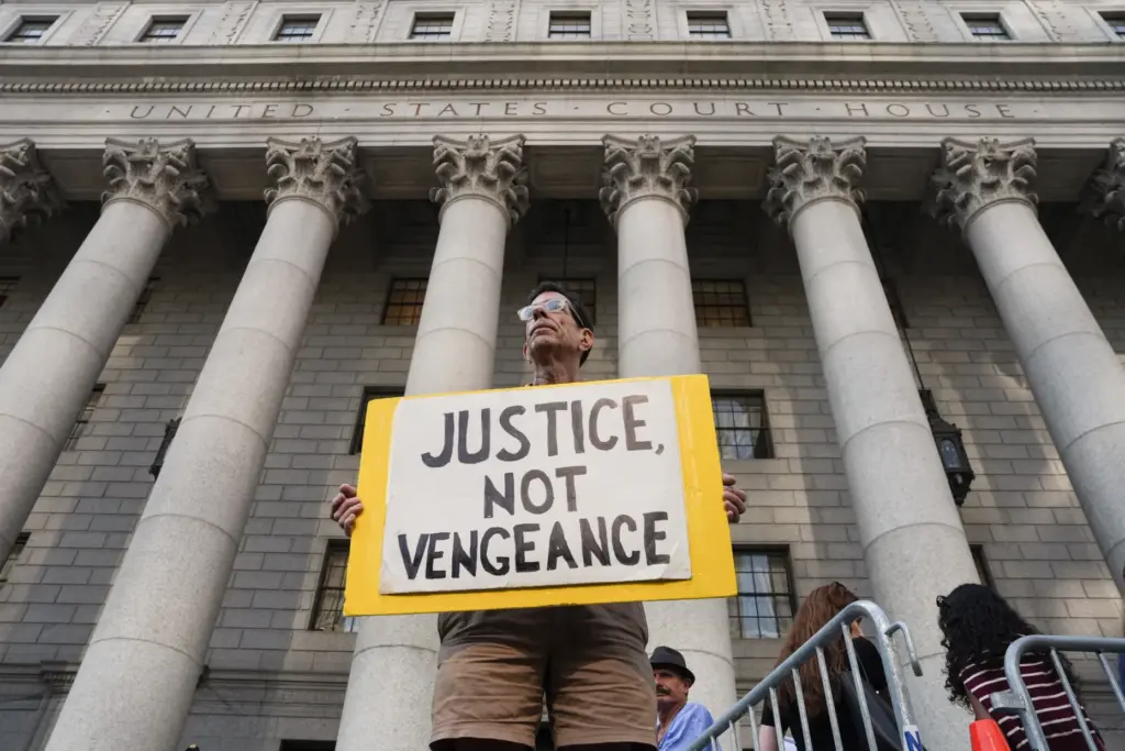 A man holds a sign outside of Manhattan Federal Court before a Luigi Mangione hearing.