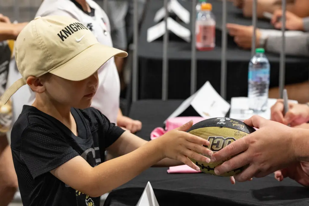 A fan hands his football to a Knightâs Football Player...