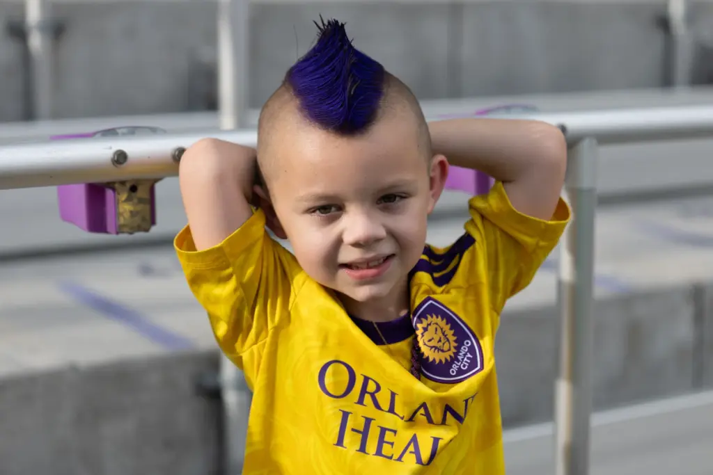 Orlando City fan Maverick Palmer sprays his mohawk purple for...