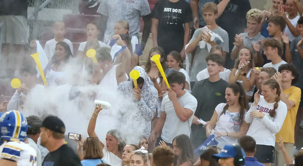 TFA students cheer and throw powder during the The First...