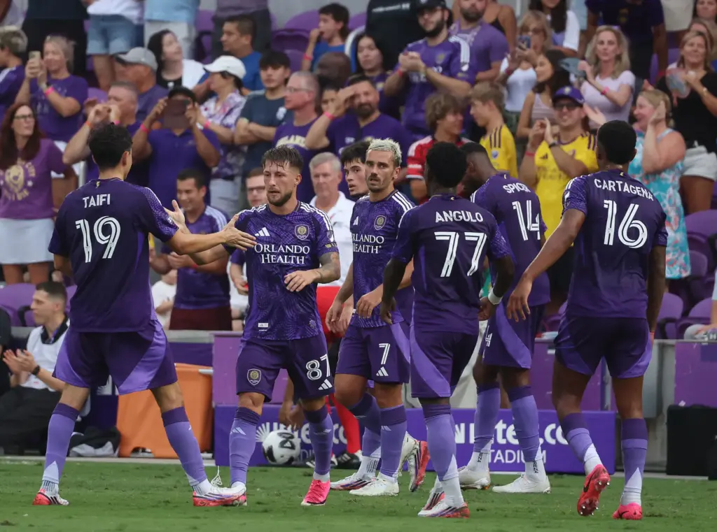 Orlando players celebrate with Marco Pasalic (87) after he scored...