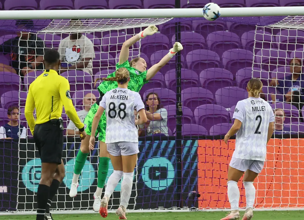 Orlando goalkeeper Anna Moorhouse (top) leaps to try to stop...