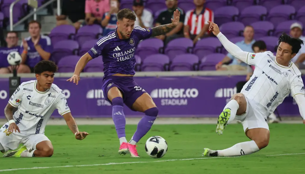 Orlando player Marco Pasalic (middle) keeps the ball from Atletico...