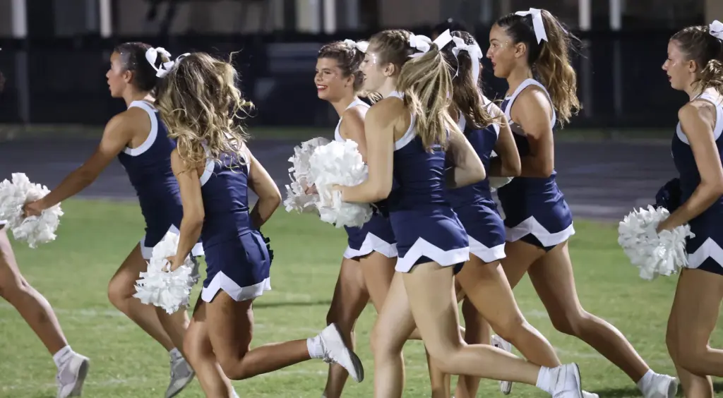 Lake Nona cheerleaders run across the field during the Evans...