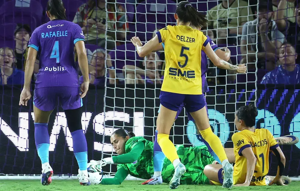 Orlando goalkeeper Cosette Morche (bottom) stops a goal attempt by...