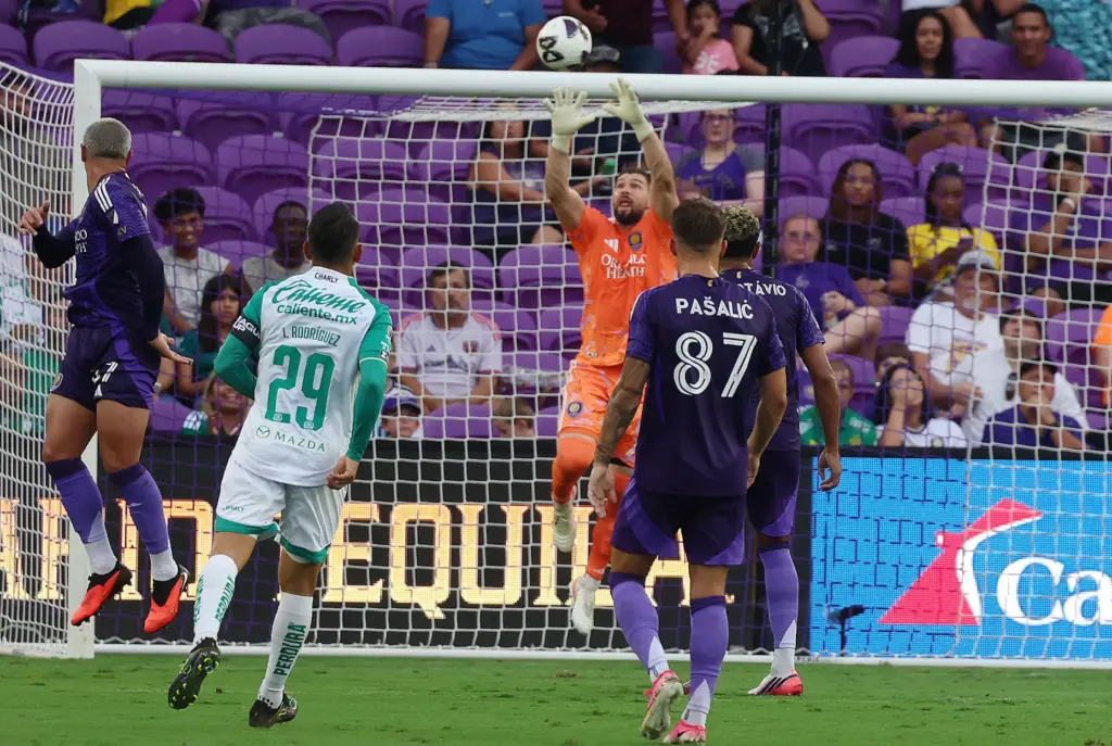 Orlando goalkeeper Maxime Crepeau leaps to stop a goal attempt...