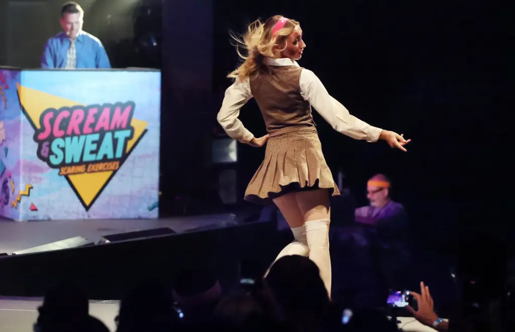 A character interacts with spectators during Scream & Sweat, an...
