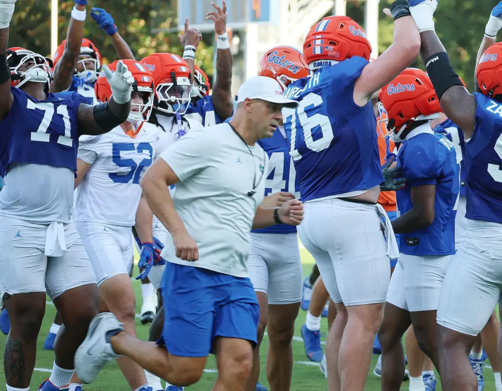 University of Florida players cheer as coach Jon Sumrall runs...