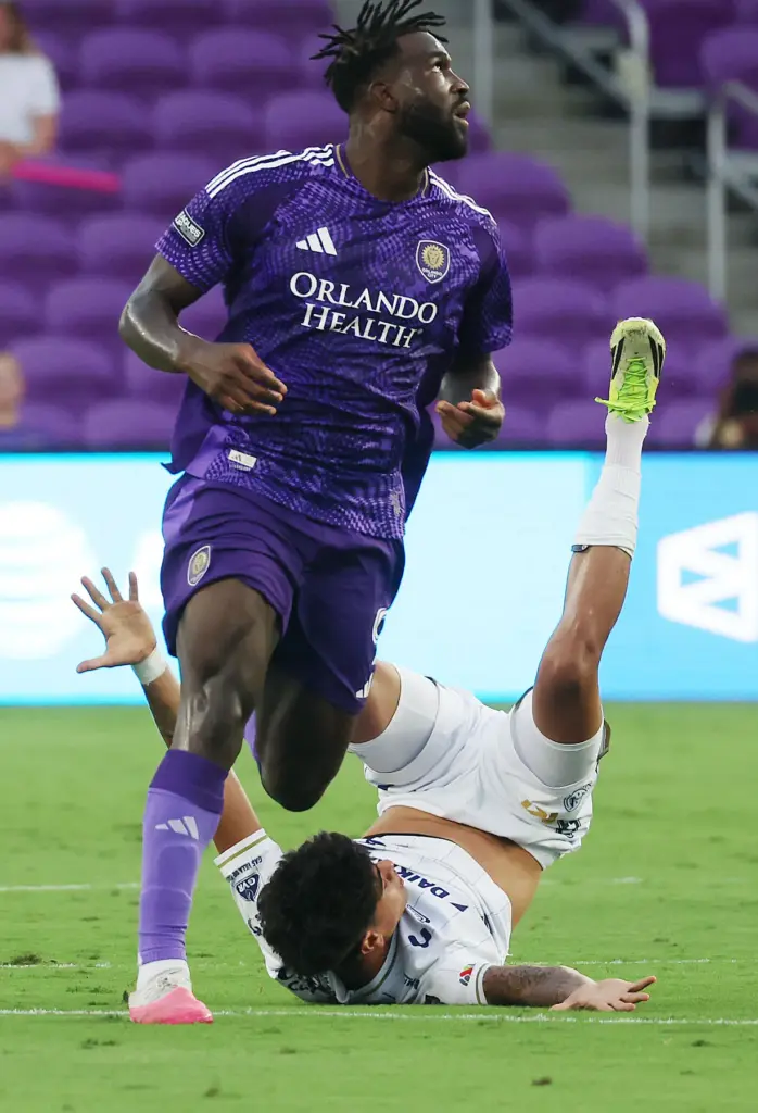 Orlando player Daryl DIke (standing) runs through Atletico player Miguel...