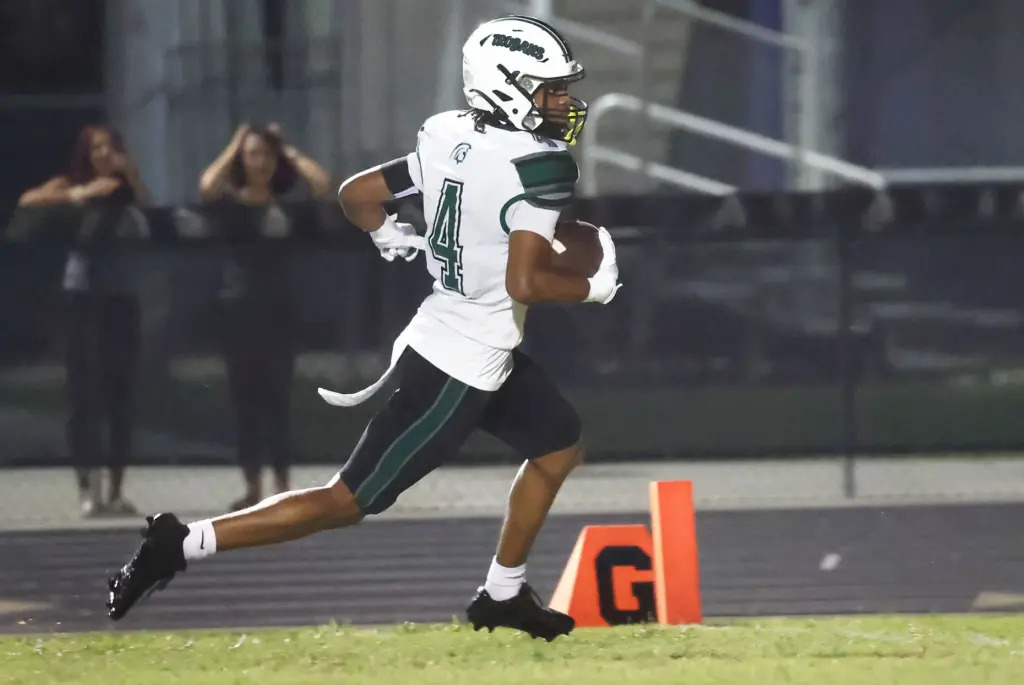 Evans High receiver Brian Dillard runs a pass in for...