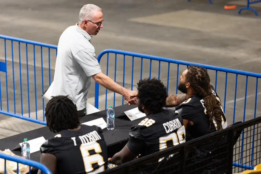 A fan shakes hands with Knightâs Football Player Sincere Edwards...