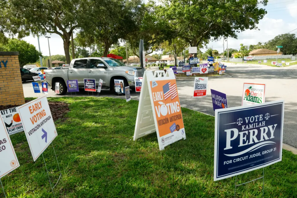 Early voting and campaign signs line the entrance to the...