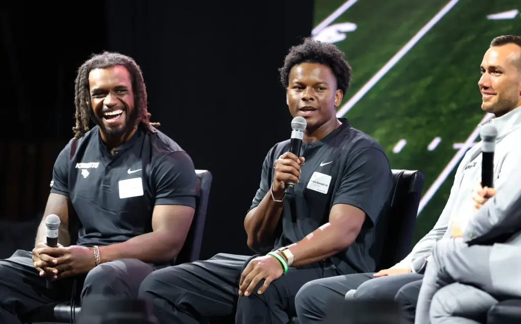 University of Central Florida starting quarterback Alonza Barnett, center, and...