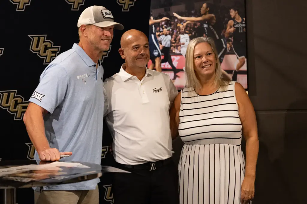 Knightâs Football Coach Scott Frost, left, takes a photo with...