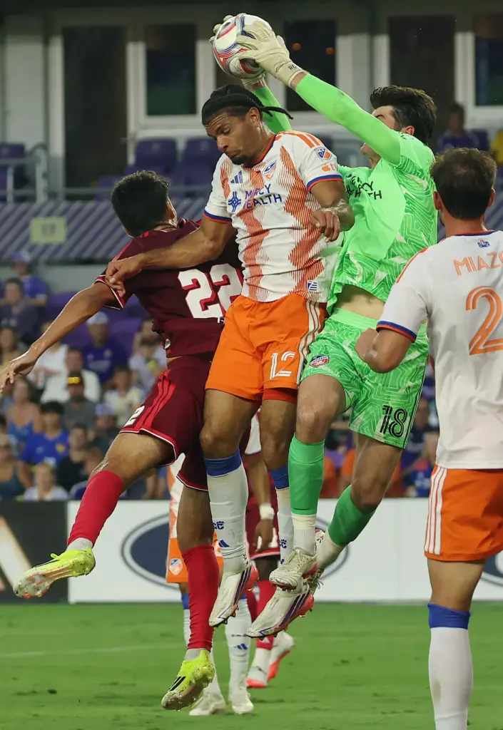 Cincinnati goalkeeper Roman Celentano (18) leaps for the ball during...