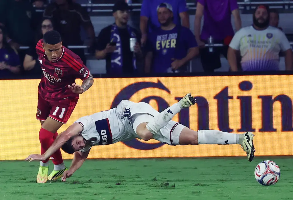 Chicago player Jonathan Dean (bottom) falls under Orlando player Tiago...
