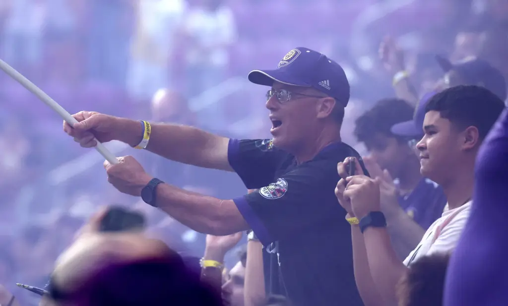Orlando fans cheer in the purple smoke after a goal...