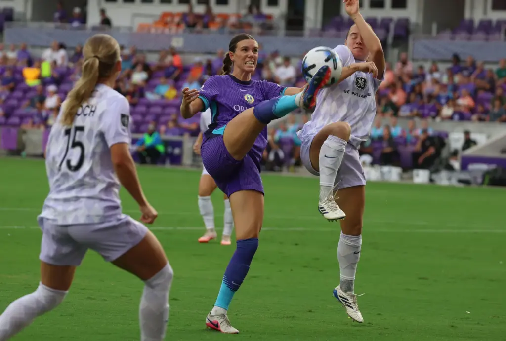 Orlando player Julie Doyle (middle) kicks during the Racing Louisville...