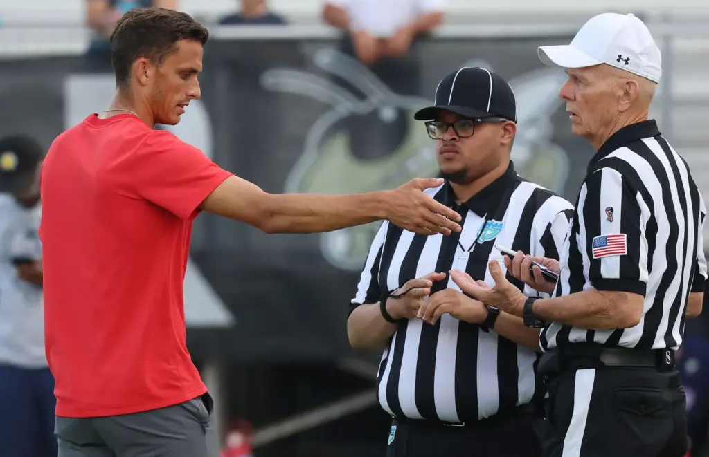 Lake Brantley head coach Garrett Kruczek talks to game officials...