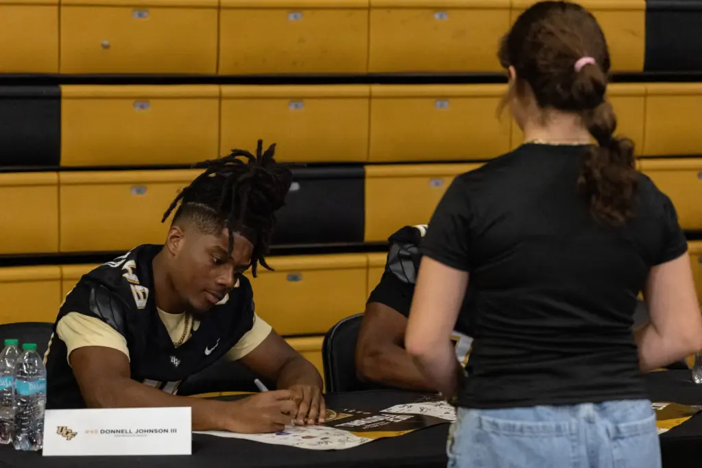 Knightâs Defensive Back Donnell Johnson III signs an autograph for...