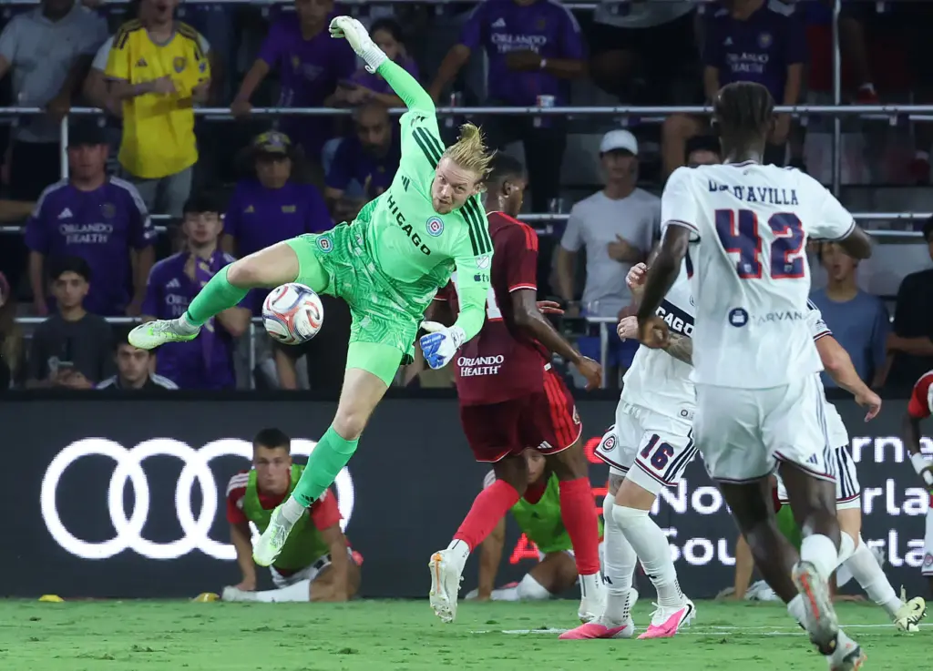 Chicago goalkeeper Chris Brady leaps to stop a ball away...