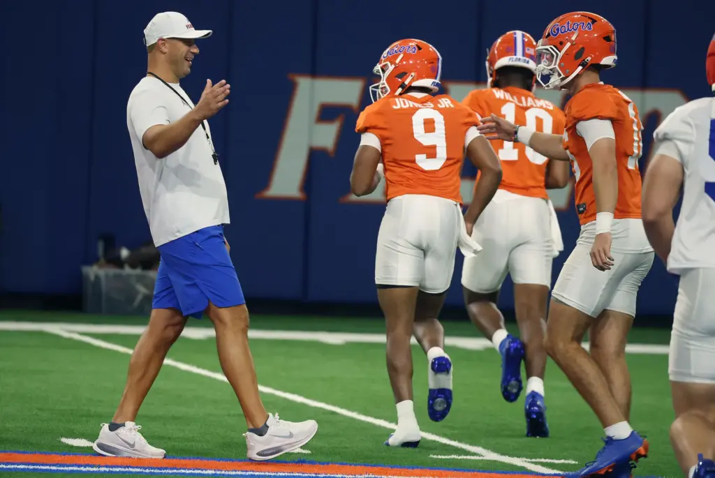 University of Florida head football coach Jon Sumrall (left) encourages...