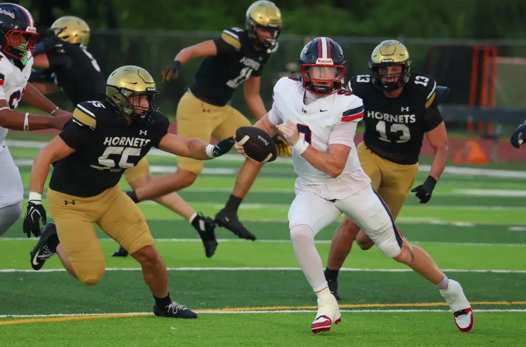 Lake Brantley quarterback Jackson Stecher (9) scrambles away from multiple...