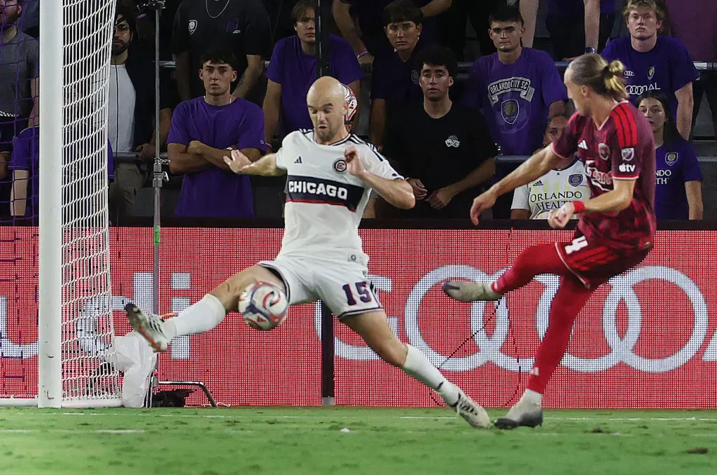 Orlando player Griffin Dorsey (right) kicks toward the net as...