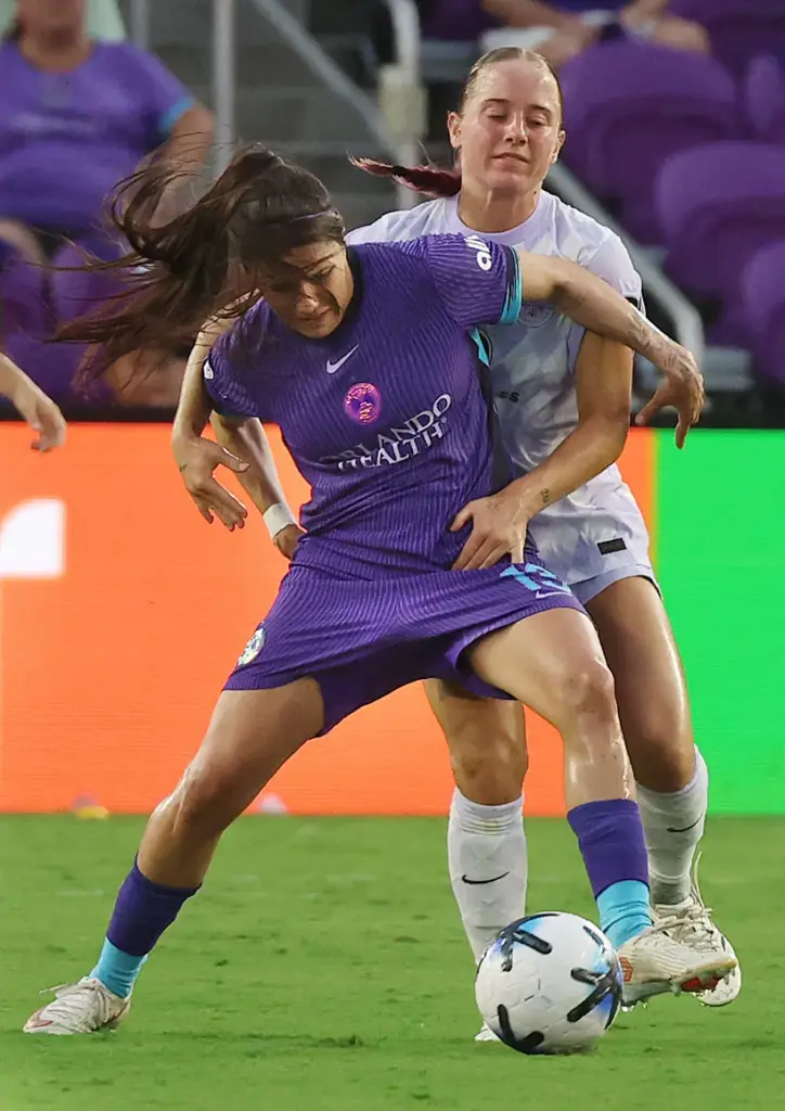 Orlando player Jacquie Ovalle (front) is grabbed by Louisville player...